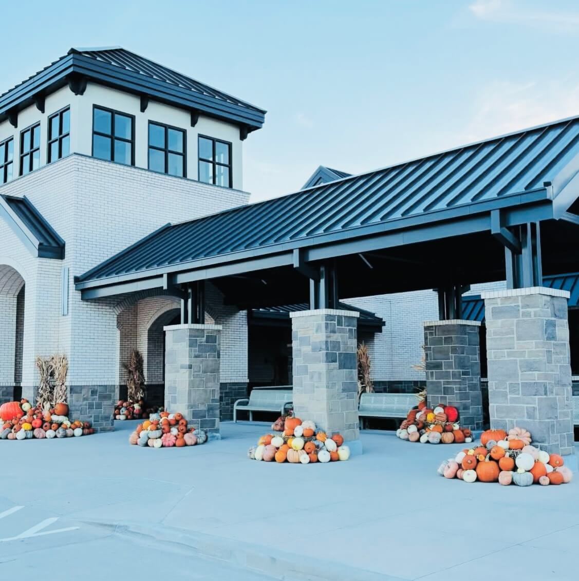 Clubhouse pumpkin Display with pumpkins, hay, and corn stalks.